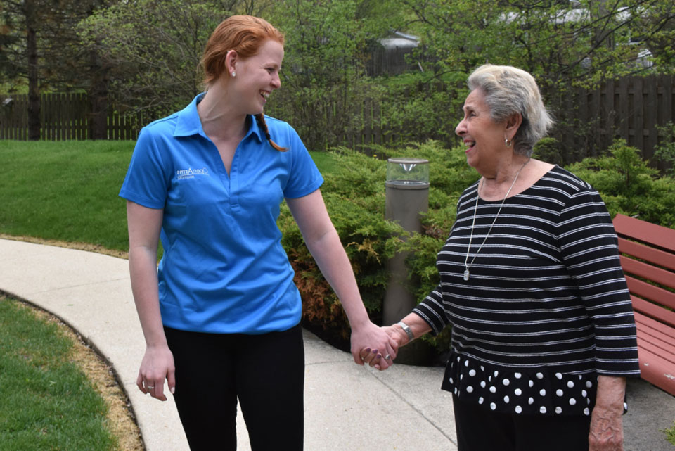 caregiver holding hands with elderly woman